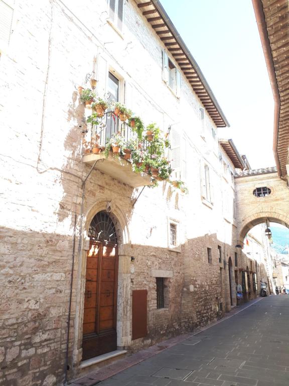 un viejo edificio con una puerta y cajas de flores. en Residenza La Luce di Assisi, en Asís