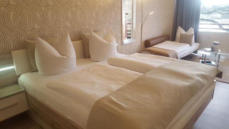 uma grande cama branca com almofadas num quarto em Appartement Ausblick em Hahnenklee-Bockswiese
