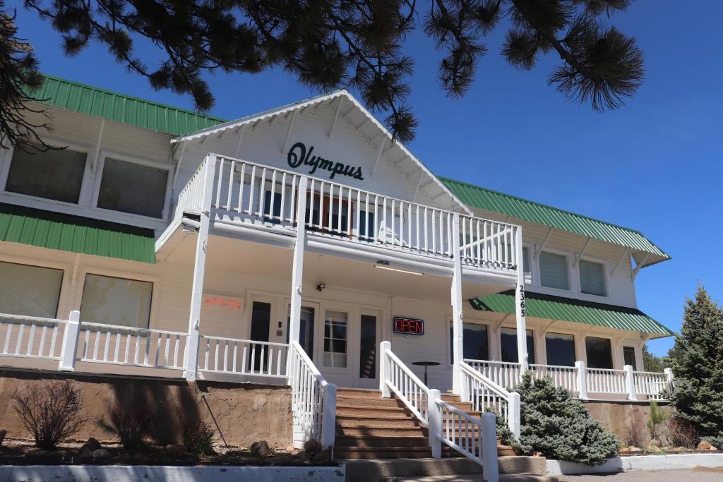 a large white building with a green roof at Olympus Lodge in Estes Park