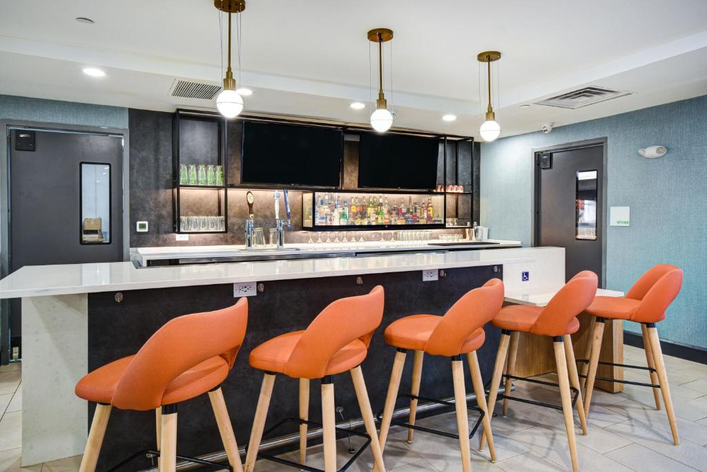a kitchen with orange chairs at a counter at Holiday Inn Allentown-Bethlehem by IHG in Allentown