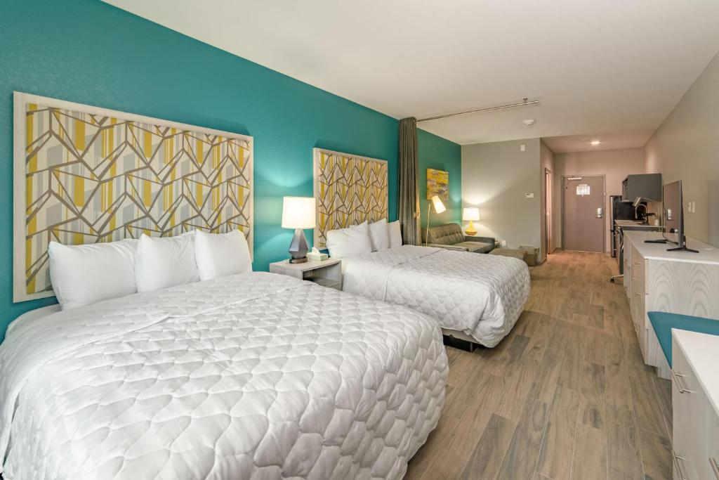 Habitación de hotel con 2 camas y paredes azules en Everglades Adventures Hotel Suites by Ivey House, en Everglades
