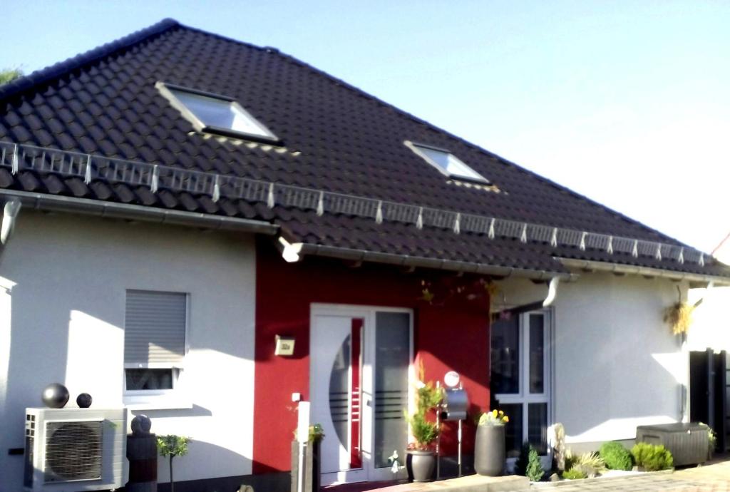 ein rotes und weißes Haus mit schwarzem Dach in der Unterkunft Fewo Schimpf Pirna in Pirna
