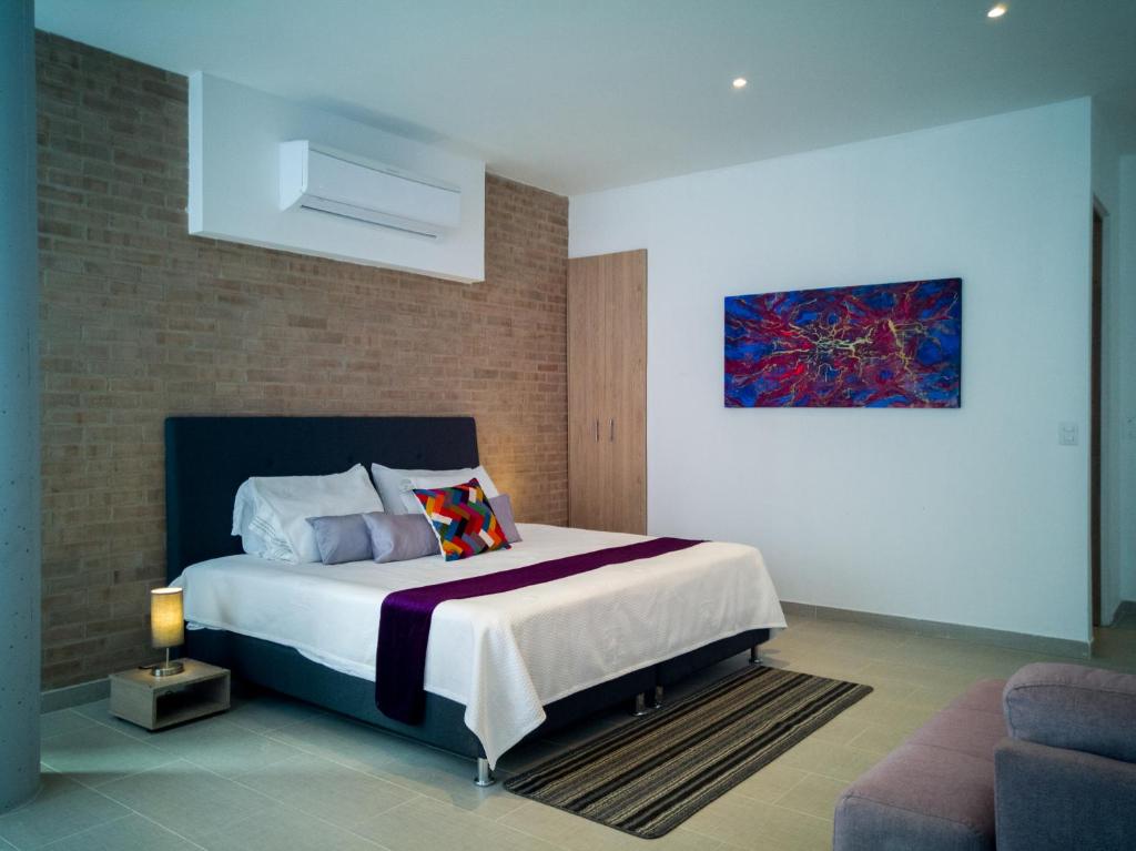 um quarto com uma cama e um quadro na parede em Hotel Boutique M em Barranquilla