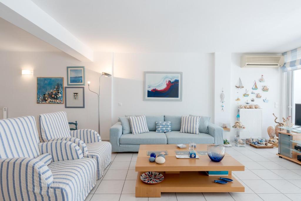 a living room with two couches and a coffee table at Beachfront Modern Apartment in Eretria