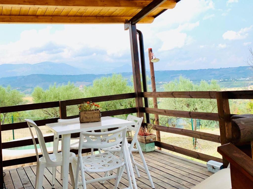 a table and chairs on a deck with a view at oasi macerina in Alanno