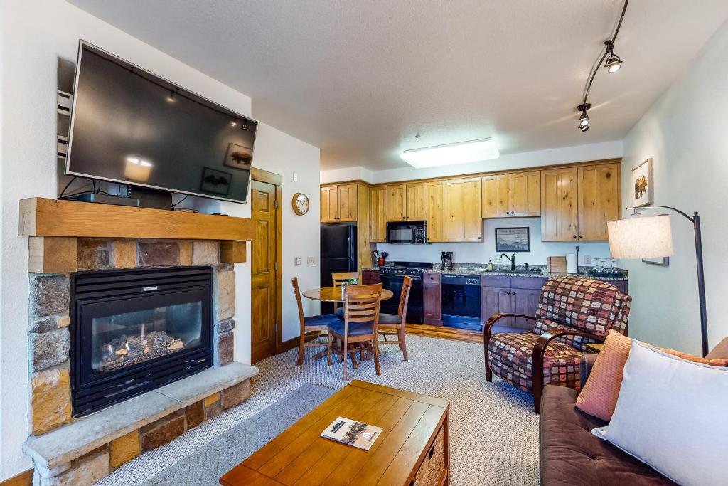 sala de estar con chimenea y cocina en Granby Ranch Getaway, en Granby