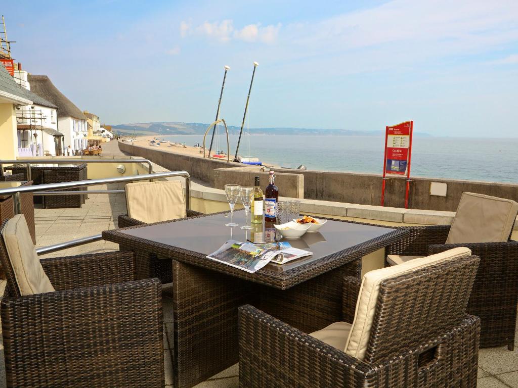 a table and chairs on a balcony with a view of the ocean at 1 At The Beach in Beesands