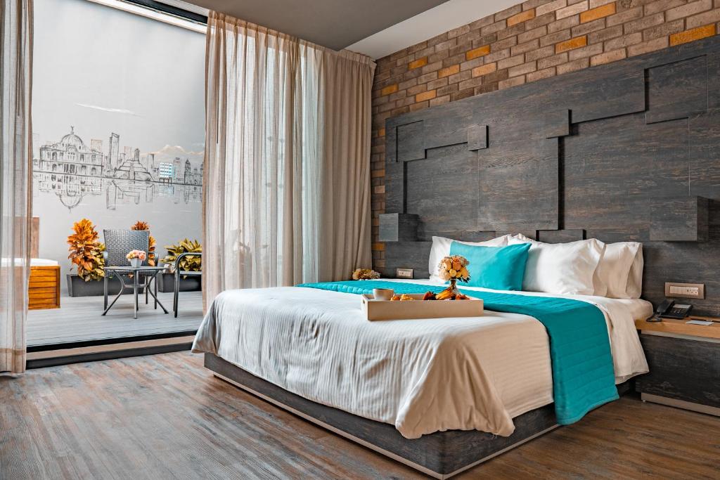 - une chambre avec un grand lit et un mur en briques dans l'établissement Hotel Punto MX, à Mexico