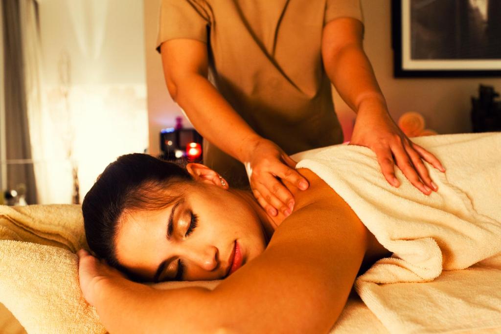 a woman getting a massage from a person in a bed at Crowne Plaza Yas Island by IHG in Abu Dhabi
