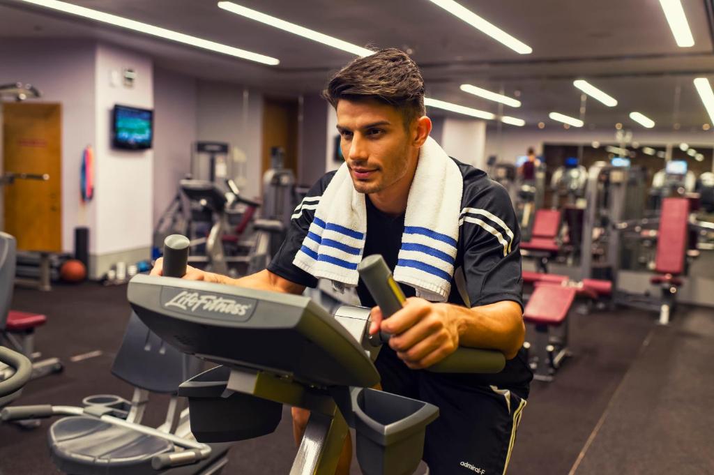 a man with a towel around his neck in a gym at Crowne Plaza Yas Island by IHG in Abu Dhabi