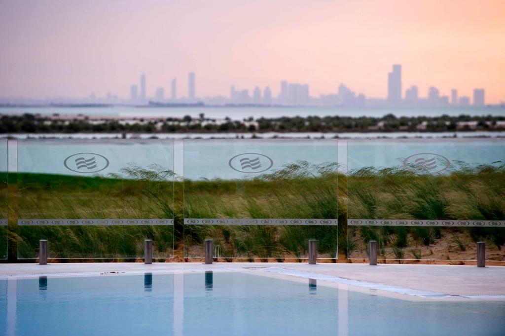 a swimming pool with a city skyline in the background at Crowne Plaza Yas Island by IHG in Abu Dhabi