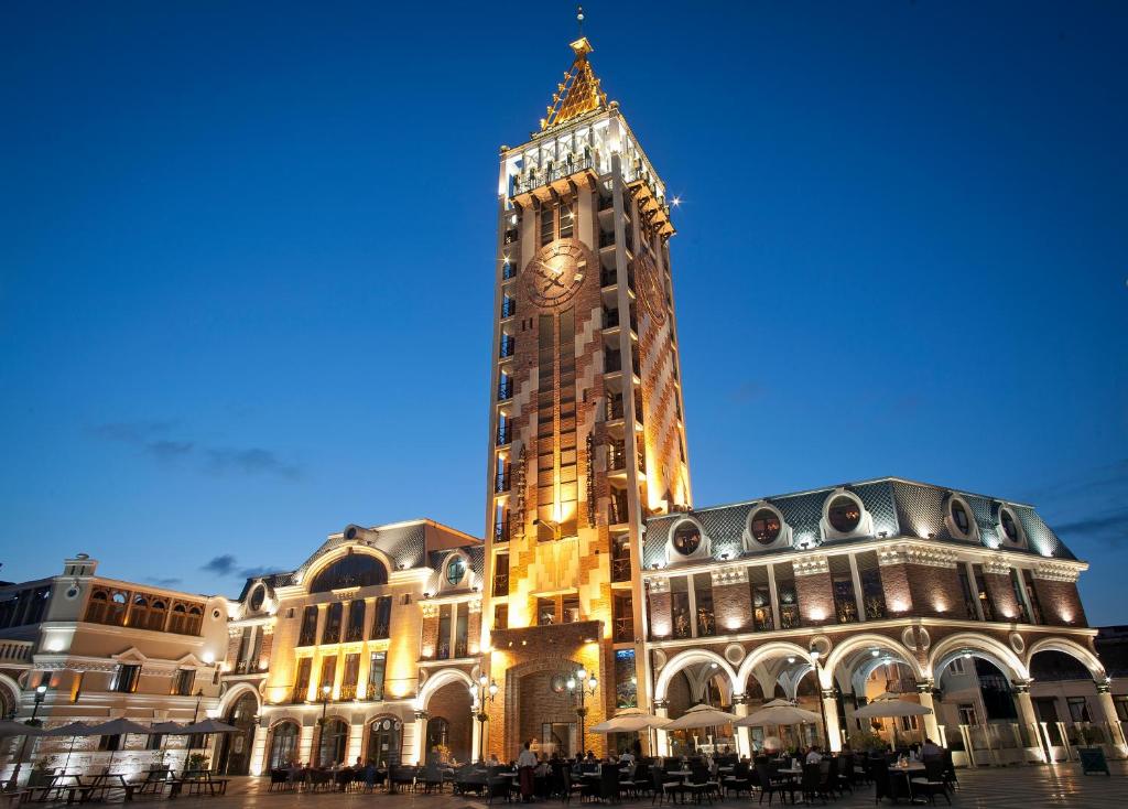 un gran edificio con una torre de reloj delante de él en Piazza Boutique Hotel, en Batumi