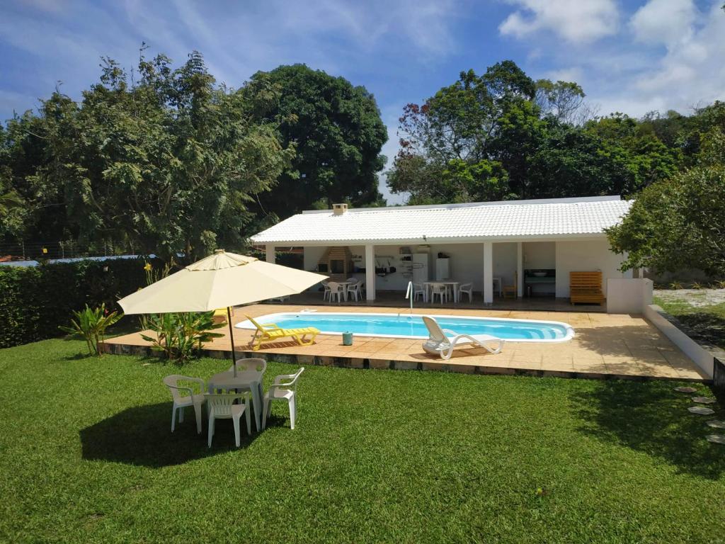 a backyard with a pool and a house at Casa em Guarajuba in Monte Gordo