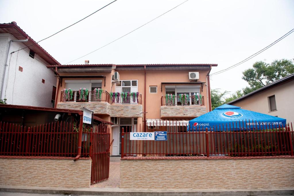 a house with a blue umbrella in front of it at Casa Ștefan in Eforie Sud