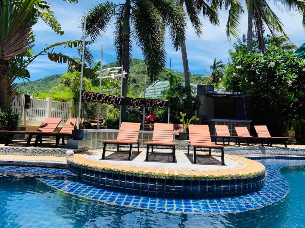 un grupo de sillas sentadas alrededor de una piscina en Delight Resort en Haad Rin