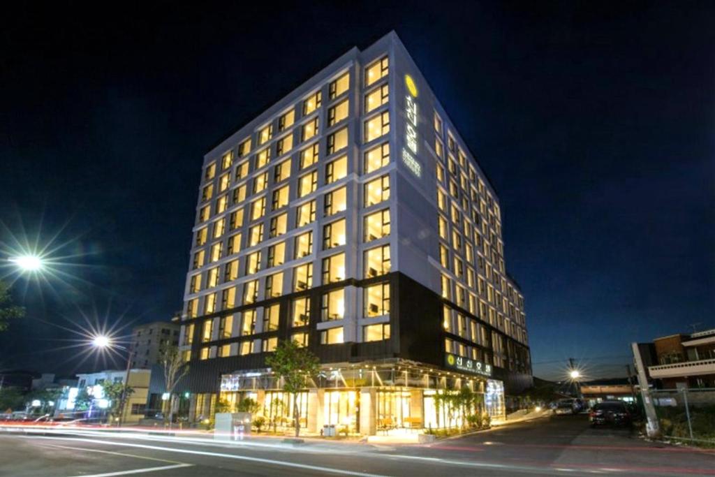 a tall black building with lit windows at night at Shin Shin Hotel Cheonjiyeon in Seogwipo