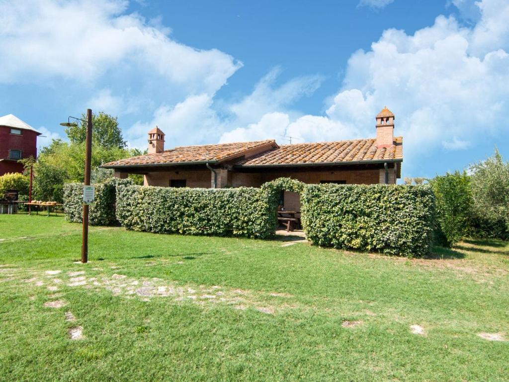 PucciarelliにあるComfy Farmhouse in Castiglione del Lago with Poolの庭前の生垣のある家