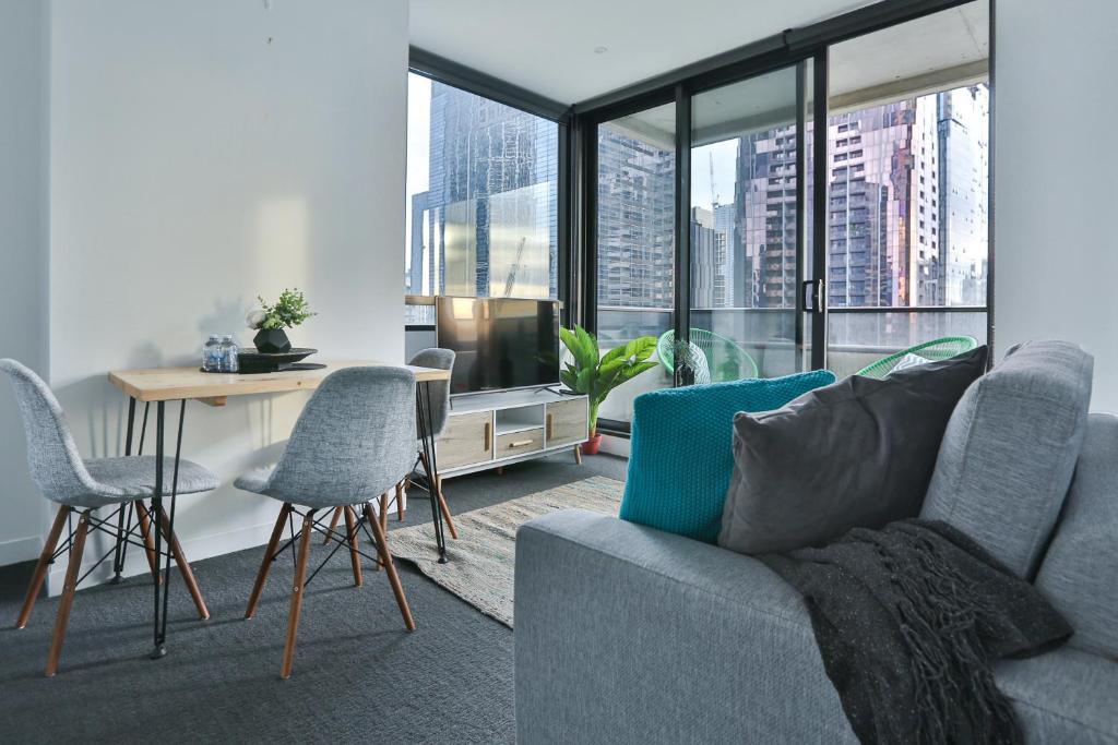 a living room with a couch and a table with chairs at MY80 Apartment located in the inner of Melbourne CBD in Melbourne