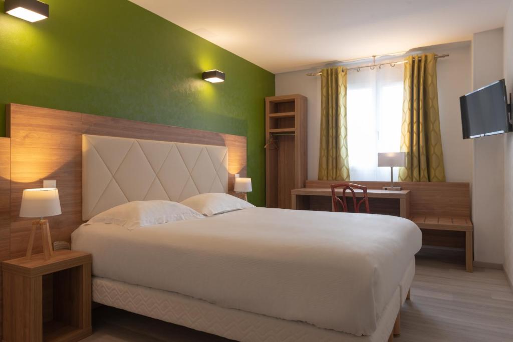 a bedroom with a white bed and a green wall at Hôtel de l'Orme, Akena in Évreux