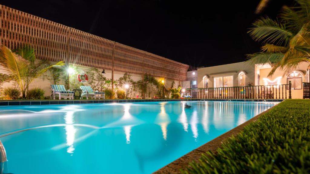 una piscina frente a un edificio por la noche en B-LBAIT Yanbu Villa Garden, en Madīnat Yanbu‘ aş Şinā‘īyah