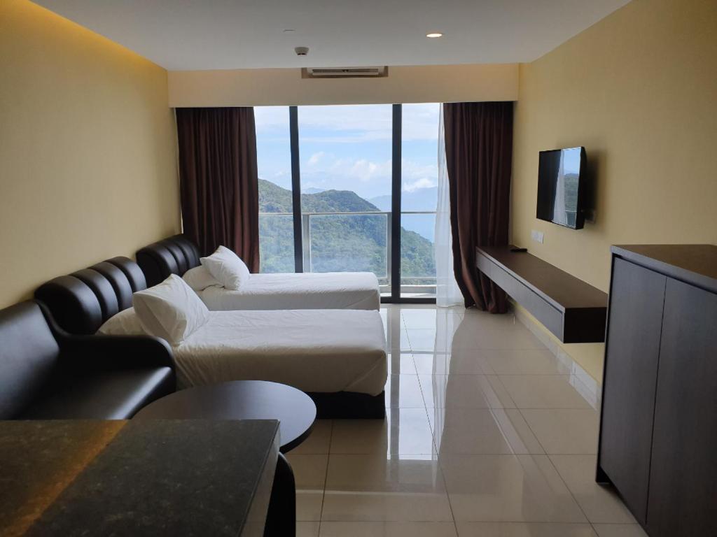 una camera d'albergo con due letti e una televisione di Studio Suite Genting Highland 33 a Resorts World Genting