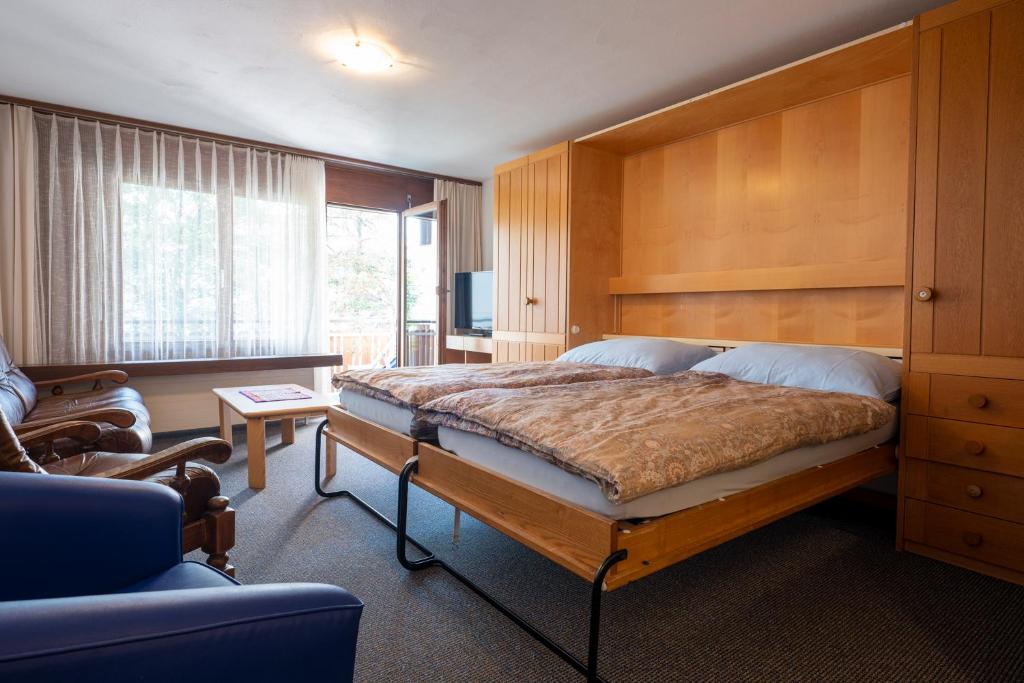 Schlafzimmer mit einem großen Bett mit einem Kopfteil aus Holz in der Unterkunft Alpablüamli in Pany