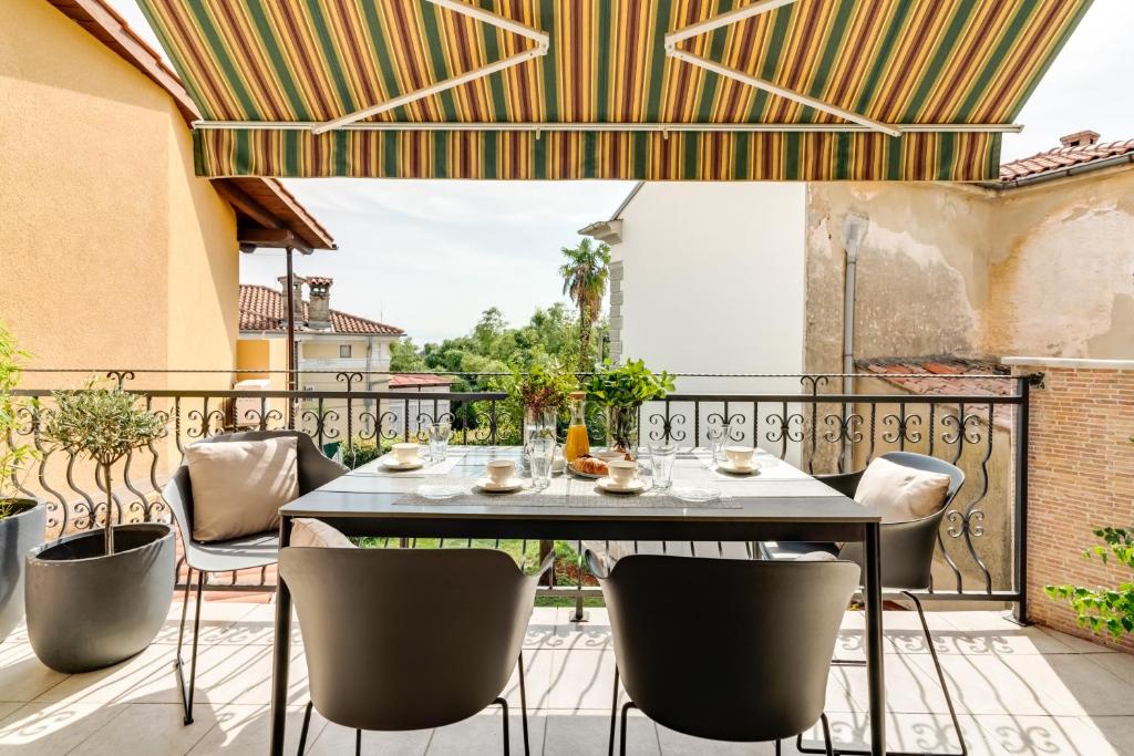 taras ze stołem i krzesłami na balkonie w obiekcie Luxury Apartment Regina w mieście Opatija