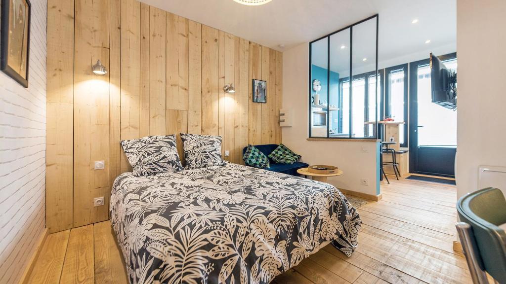 een slaapkamer met een bed in een kamer met houten wanden bij L'Atelier Corval in Le Mans