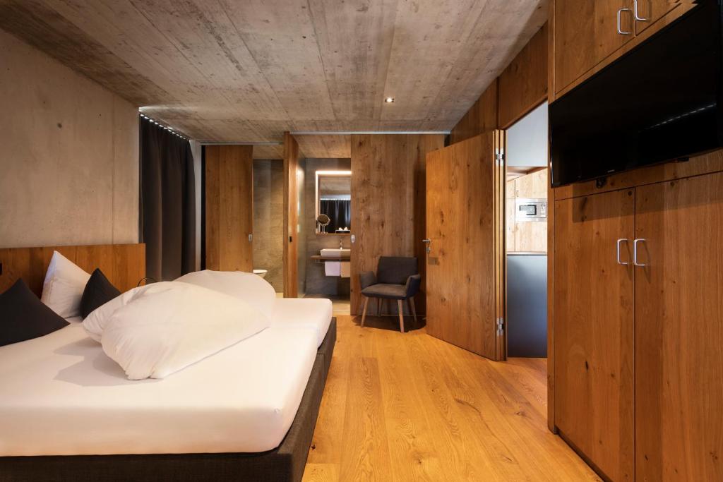 a bedroom with a bed and wooden cabinets and a television at Apart6580 in Sankt Anton am Arlberg