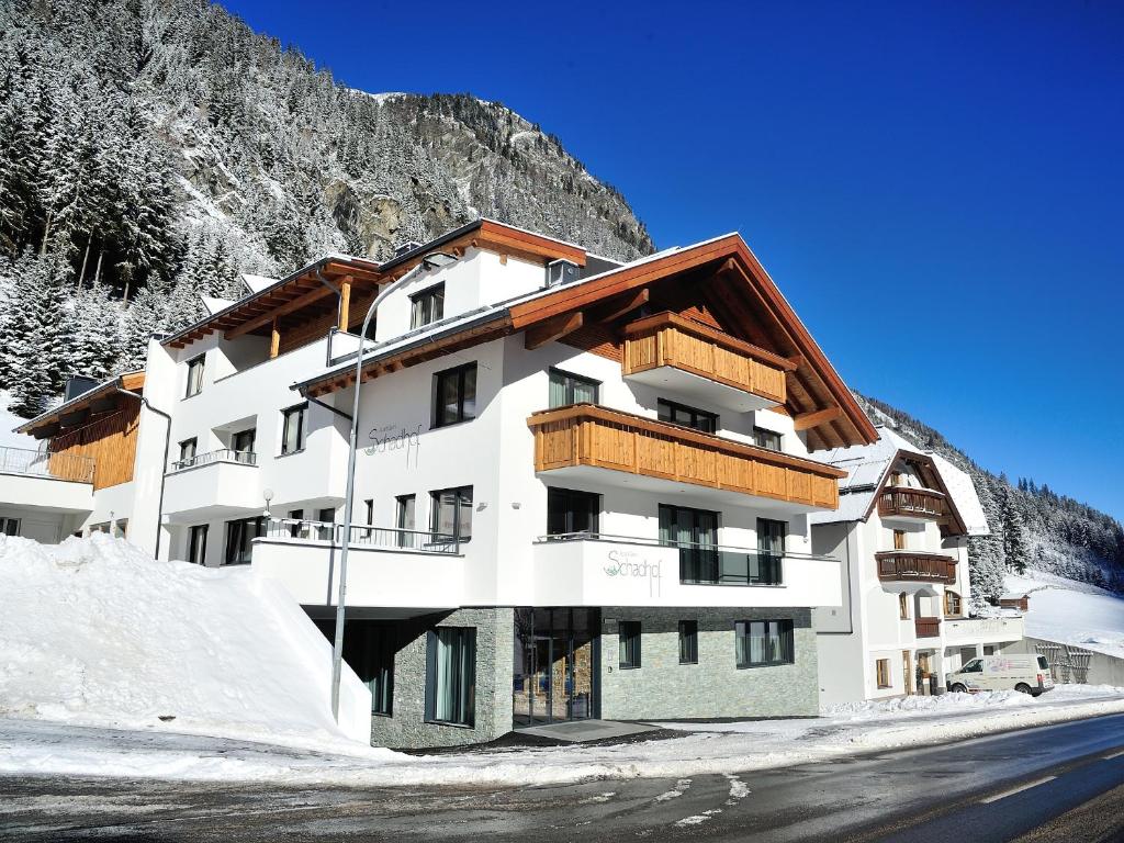 un edificio en las montañas con nieve en el suelo en Apart Garni Schadhof, en Ischgl