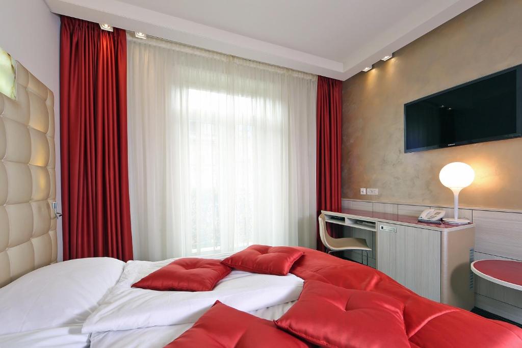 a bedroom with a large bed with red pillows at Hotel St.Gotthard in Zürich