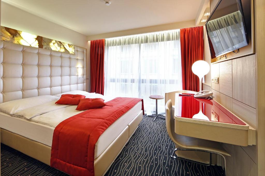 a bedroom with a large bed and a flat screen tv at Hotel St.Gotthard in Zürich