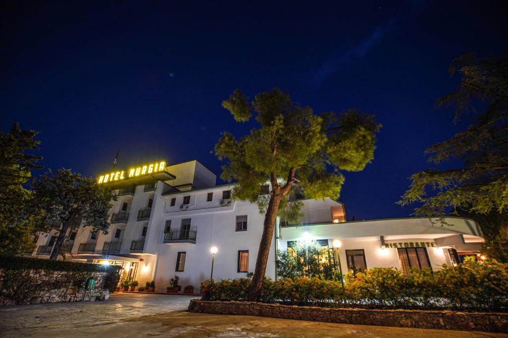 a white building with a sign on top of it at Hotel Murgia in Santeramo in Colle