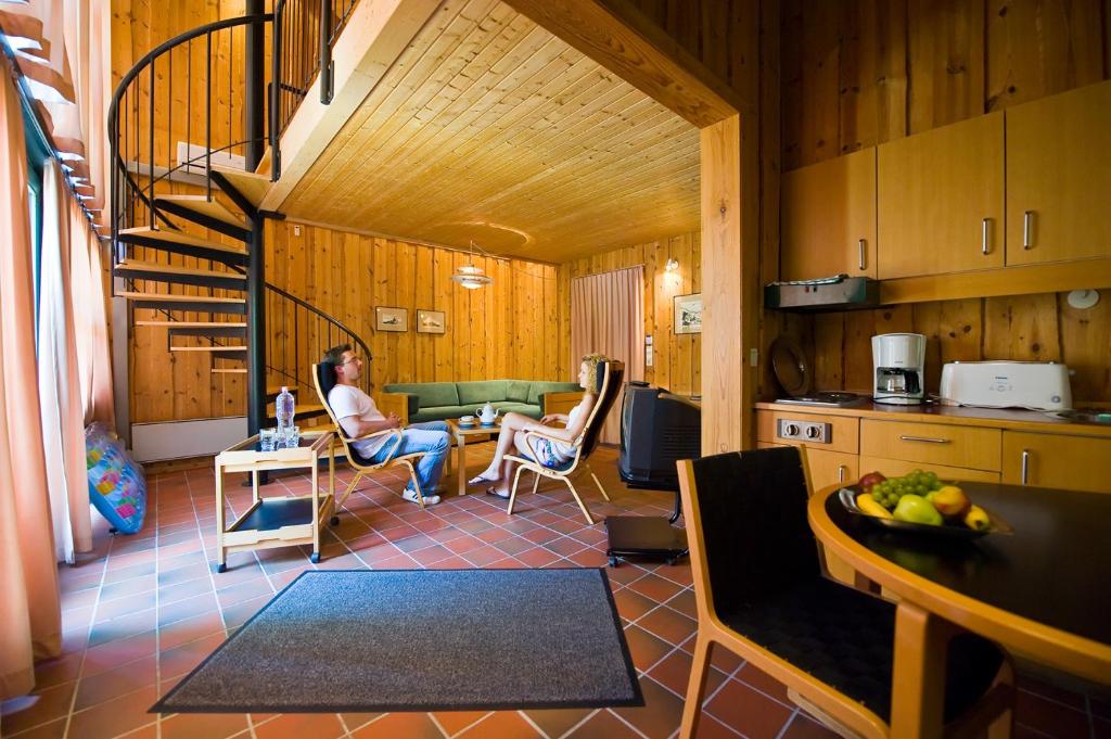 a man sitting in the kitchen of a cabin at Club Tihany Bungalows in Tihany