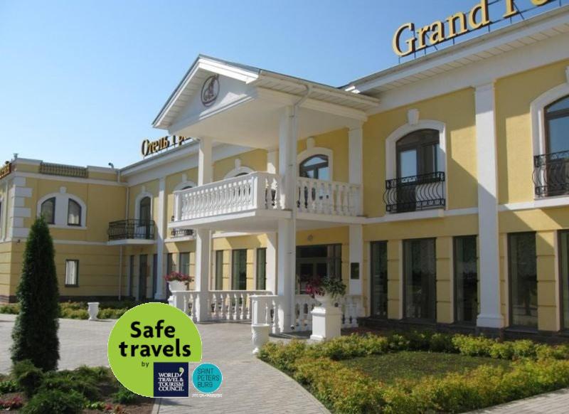 a large yellow building with a sign that reads safe travels at Grand Peterhof Spa Hotel in Petergof