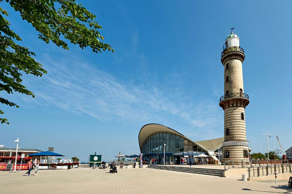 a lighthouse in front of a building with a building at Hotel Belvedere in Warnemünde