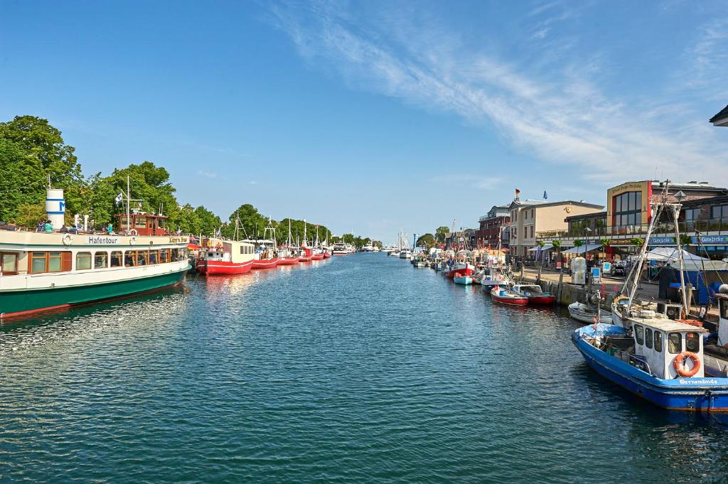 a group of boats are docked in a river at Hotel Belvedere in Warnemünde