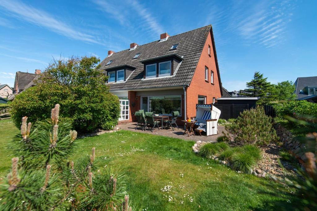 a large house with a yard with a lawn sidx sidx sidx at Haus 32 in Wenningstedt
