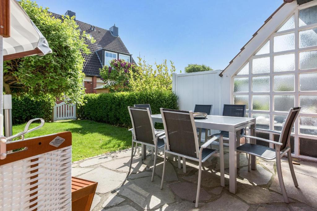 a patio with a table and chairs in a yard at Alte Liebe in Westerland (Sylt)