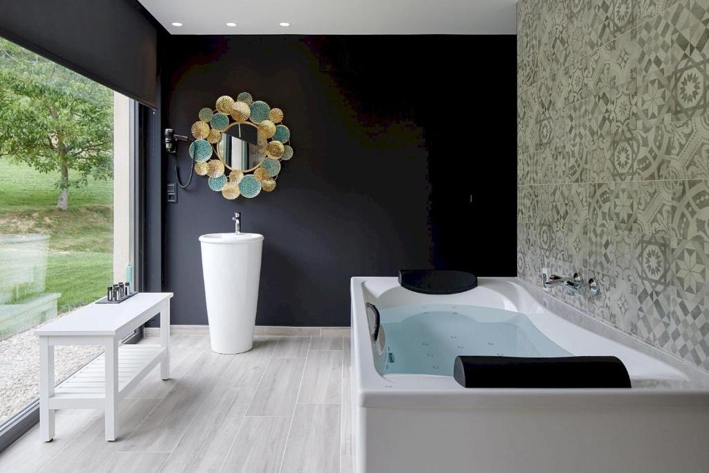 a bathroom with a tub and a table and a mirror at Oribar Casa Rural in Aia