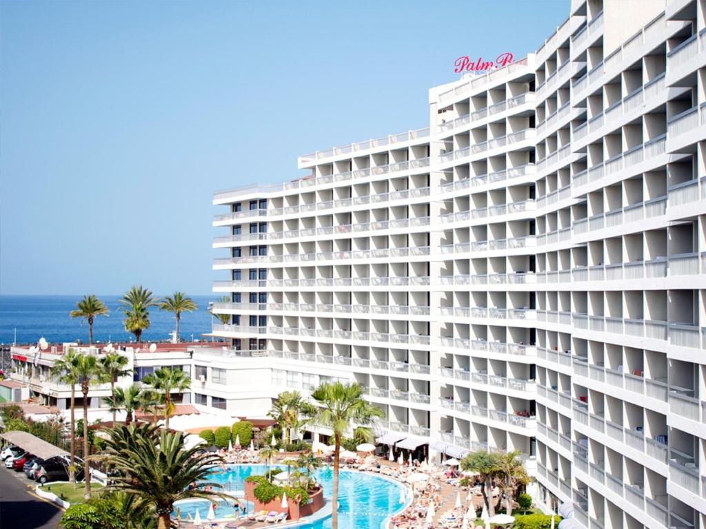 a view of a large hotel with a pool and the ocean at Palm Beach - Excel Hotels & Resorts in Playa de las Americas