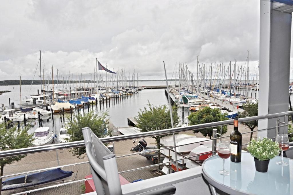 un balcone con tavolo e un porto turistico con barche di Börn Börn Miesmuschel a Laboe