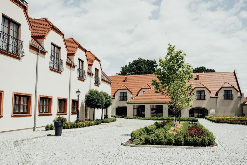 une cour d'une rangée de maisons avec un arbre dans l'établissement Hotel Pałac Krotoszyce Basen&Spa, à Krotoszyce