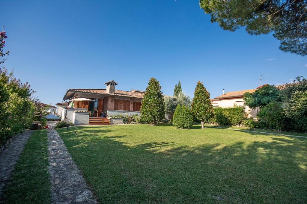 una casa con un cortile verde con una casa di Villa Orsini - A Retreat in Pisa - Food and Relax a Pisa