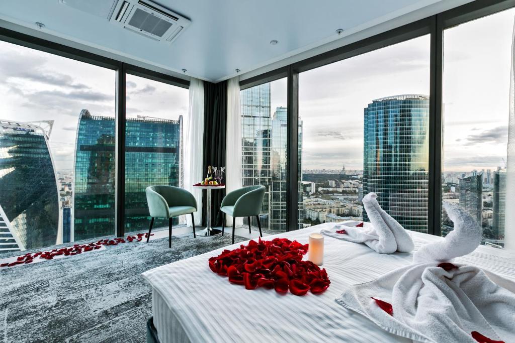 um quarto com uma cama com rosas vermelhas em Panorama City Federation em Moscovo