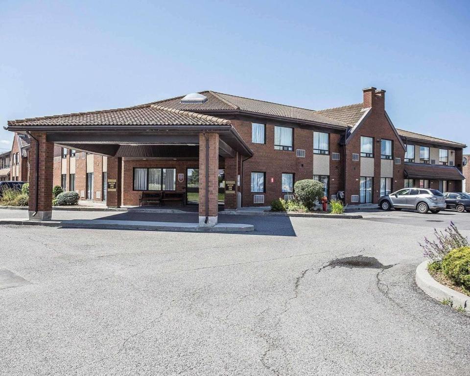 un grand bâtiment en briques avec un pavillon dans un parking dans l'établissement Comfort Inn Gatineau, à Gatineau