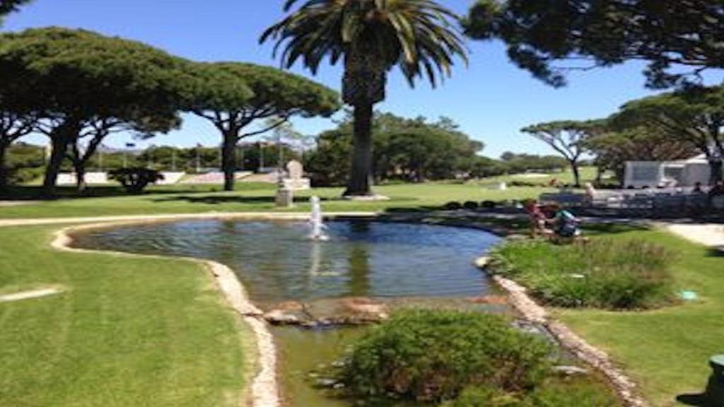 a pond in a park with a fountain at Villa Da Colina - front line villa over looking the beach and golf course in Vale Do Lobo in Vale do Lobo