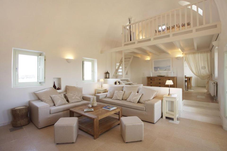 a living room with a couch and a loft at w Villa Black Rock Santorini in Akrotiri