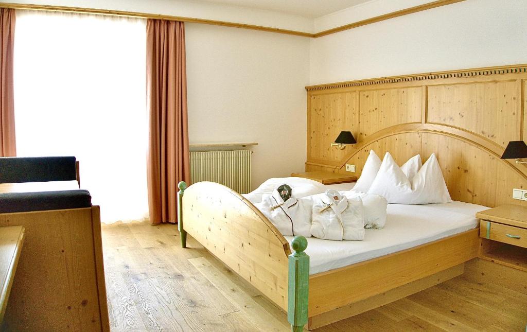 una camera da letto con un grande letto con cuscini bianchi di Hotel Adlernest a Senales