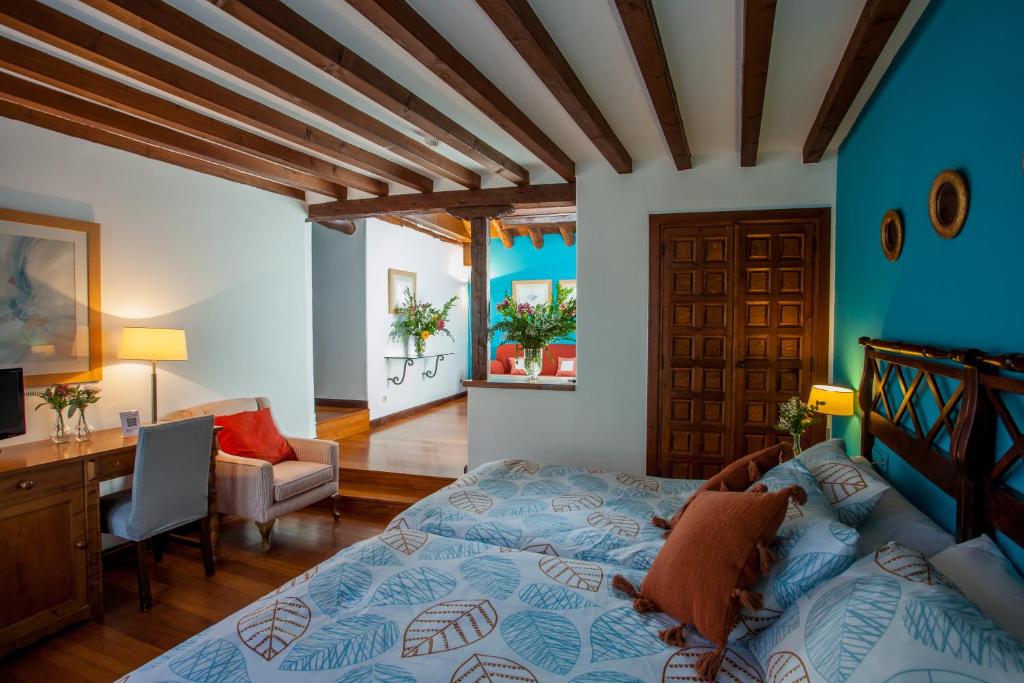 a bedroom with a bed and a desk and a desk at Hotel Casa Palacio Uclés in Uclés